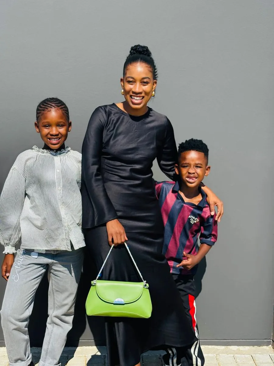 A South African mother with her two children, dressed up and smiling together